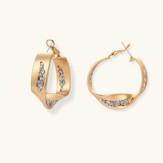 Gold circular pendant necklace with crystals on black cord paired with matching geometric hoop earrings on white background.